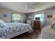 Bright bedroom features a ceiling fan and blue patterned quilt at 3550 100Th N Pl, Pinellas Park, FL 33782