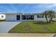 Charming single-story home with a well-maintained lawn, fresh gray paint, and a new driveway at 3550 100Th N Pl, Pinellas Park, FL 33782