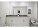 Bathroom with a double sink vanity featuring granite countertops and white cabinets at 36419 Garden Wall Way, Zephyrhills, FL 33541