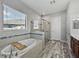 Bathroom with soaking tub, glass shower, and wood-look tile flooring at 4043 Salida Del Sol Dr, Sun City Center, FL 33573
