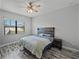 Bedroom with wood-look tile floors, ceiling fan, and rustic wood headboard at 4043 Salida Del Sol Dr, Sun City Center, FL 33573