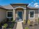 An inviting front entrance with a stylish blue door, manicured landscaping, and great natural light at 4043 Salida Del Sol Dr, Sun City Center, FL 33573
