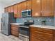 Kitchen features stainless steel appliances, wood cabinets, tile backsplash, and plenty of counter space at 4043 Salida Del Sol Dr, Sun City Center, FL 33573