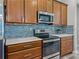 The kitchen has stainless appliances, wood cabinets, stylish tile backsplash, and solid surface counters at 4043 Salida Del Sol Dr, Sun City Center, FL 33573