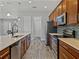 A kitchen with stainless appliances, wood cabinets, and a large island with sink and dishwasher at 4043 Salida Del Sol Dr, Sun City Center, FL 33573