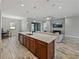 Open concept kitchen with island, stainless appliances, and views of the living room at 4043 Salida Del Sol Dr, Sun City Center, FL 33573