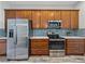 Kitchen offers stainless steel appliances, wood cabinets, ample countertop space, and tile backsplash at 4043 Salida Del Sol Dr, Sun City Center, FL 33573