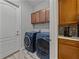 Laundry room with side-by-side washer and dryer and overhead storage cabinets at 4043 Salida Del Sol Dr, Sun City Center, FL 33573