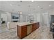 Open concept kitchen and living room featuring wood-look floors, stainless steel appliances, and ample seating at 4043 Salida Del Sol Dr, Sun City Center, FL 33573