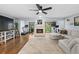 Bright living room with hardwood floors, fireplace, ceiling fan, and exercise equipment at 4115 Brentwood Park Cir, Tampa, FL 33624