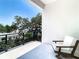 Relaxing outdoor balcony includes modern chair, railing, and scenic treetop views at 4816 W San Jose St, Tampa, FL 33629