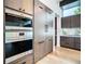 Stainless steel Wolf oven and refrigerator with modern dark gray cabinetry and wooden floor at 4816 W San Jose St, Tampa, FL 33629