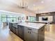 Gourmet kitchen with large island, chef's range, modern lighting, stainless sink, and wood floor at 4816 W San Jose St, Tampa, FL 33629