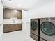 Spacious laundry room includes modern washer and dryer units and storage cabinets at 4816 W San Jose St, Tampa, FL 33629