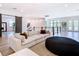 Open living room with plush sofa, beanbag, wood floors, and seamless indoor-outdoor flow at 4816 W San Jose St, Tampa, FL 33629