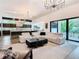 Spacious living room with modern chandelier, a large sectional, and sliding glass doors to the outdoor space at 4816 W San Jose St, Tampa, FL 33629