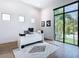 Bright home office featuring a modern white desk, a geometric rug, and a large window with a lush outdoor view at 4816 W San Jose St, Tampa, FL 33629