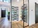 Modern glass wine cellar and wine racks with wooden floors, glass doors, and a view into entry at 4816 W San Jose St, Tampa, FL 33629