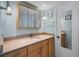 Bathroom featuring wooden cabinets, a large mirror and a solid surface counter at 5000 Gulf Blvd # 304, St Pete Beach, FL 33706