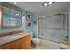 Bright bathroom featuring a shower with glass doors and a wood vanity with a granite countertop at 5000 Gulf Blvd # 304, St Pete Beach, FL 33706