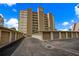 Exterior of building with garages, manicured landscaping and private parking at 5000 Gulf Blvd # 304, St Pete Beach, FL 33706