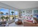 Inviting living room with a beachfront view, floral couch, and glass coffee table at 5000 Gulf Blvd # 304, St Pete Beach, FL 33706