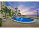 Beautiful community pool near beach, featuring lush tropical landscaping and lounge chairs at 5000 Gulf Blvd # 304, St Pete Beach, FL 33706