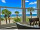 Stunning ocean view from a large window, showcasing palm trees and white sand at 5000 Gulf Blvd # 304, St Pete Beach, FL 33706
