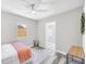 Bedroom featuring wood-look floors, ceiling fan, backyard view, and access to the bathroom at 5050 Emerson S Ave, St Petersburg, FL 33707