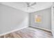 Minimalist bedroom with modern ceiling fan, neutral walls, wood-look flooring, and a backyard view at 5050 Emerson S Ave, St Petersburg, FL 33707