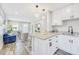 Open-concept kitchen with granite island flowing into a sunlit living space. Fresh, modern design at 5050 Emerson S Ave, St Petersburg, FL 33707