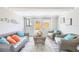 Bright living room featuring wicker furniture, neutral walls, and wood-look floors at 5050 Emerson S Ave, St Petersburg, FL 33707