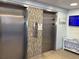 Elevators featuring stainless steel doors, tiled wall accents, and a display screen at 5108 Brittany S Dr # 903, St Petersburg, FL 33715