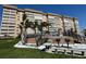 Exterior shot of a large condo building with palm trees and a grilling area surrounded by well-manicured grounds at 5108 Brittany S Dr # 903, St Petersburg, FL 33715