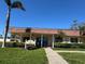 A sunny exterior view of a cream-colored management office building, framed by lush landscaping and palm trees at 5108 Brittany S Dr # 903, St Petersburg, FL 33715