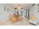 Cozy dining area featuring a glass table, four rattan chairs, built-in shelving and tiled flooring at 708 Tamiami S Trl # 112, Venice, FL 34285