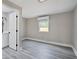 Bedroom featuring gray wood floors, neutral paint, and a window with natural light at 8308 N Mulberry St, Tampa, FL 33604