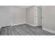 Bedroom with gray wood floors, neutral paint, and white doors at 8308 N Mulberry St, Tampa, FL 33604