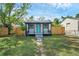 Charming home featuring a cozy front porch and a bright, inviting blue front door at 8308 N Mulberry St, Tampa, FL 33604