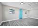 Clean, well-lit room featuring neutral walls, wood floors, and a pop of color with a turquoise door at 8308 N Mulberry St, Tampa, FL 33604