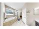 Bathroom features a soaking tub under a window and glass enclosed shower at 8436 White Poplar Dr, Riverview, FL 33578