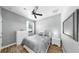 Bedroom with wood floors, ceiling fan, dresser, and large window at 8436 White Poplar Dr, Riverview, FL 33578