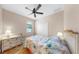 Bedroom with light walls, white trim, wood floors, and large window at 8436 White Poplar Dr, Riverview, FL 33578