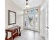 Bright foyer with decorative glass front door, stylish console table and tile flooring at 8436 White Poplar Dr, Riverview, FL 33578
