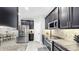Modern kitchen featuring stainless steel appliances, granite countertops, and dark cabinetry at 8436 White Poplar Dr, Riverview, FL 33578