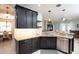 Modern open kitchen featuring dark cabinets, stainless steel appliances, and light granite countertops at 8436 White Poplar Dr, Riverview, FL 33578