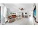 Open-concept living room showcasing tile floors, neutral tones, and seamless flow to the kitchen and dining areas at 8436 White Poplar Dr, Riverview, FL 33578