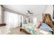Well-lit main bedroom boasting wood-look floors, a ceiling fan, and curtains for a relaxing and comfortable atmosphere at 8436 White Poplar Dr, Riverview, FL 33578
