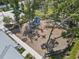 Community playground with slides, swings, and benches, surrounded by mature trees and a secure fence at 8436 White Poplar Dr, Riverview, FL 33578