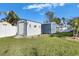 View of backyard with two utility sheds on a green lawn with partial fencing at 8611 Parkway Cir, Riverview, FL 33569